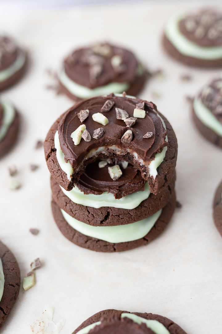 Andes Mint Cookies stacked on top of each other on the counter with a bite taken out of the cookie on top.