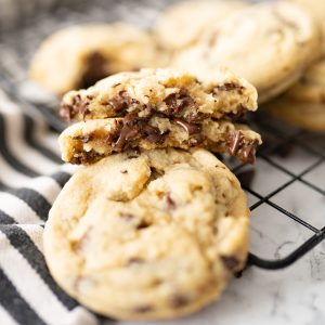 A cookie made without eggs broken in half and stacked on top of each other so the gooey, chocolate chips are melting out.