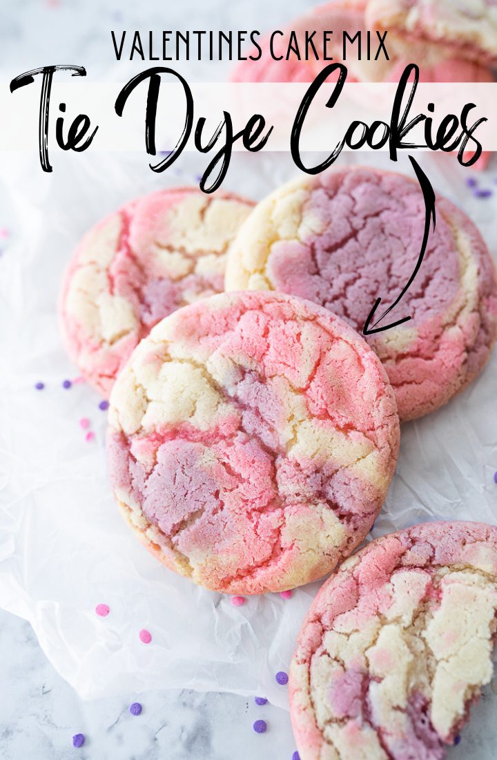 A few tie dye cookies stacked on the counter with pink sprinkles in the background and text on the photo that reads "Valentine's Cake Mix Tie Dye Cookies."