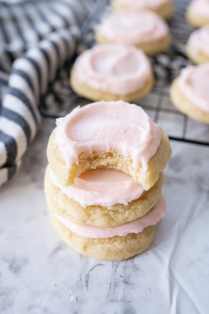 Small crumbl sugar cookies stacked on top of each other with a bite taken out of the top cookie.