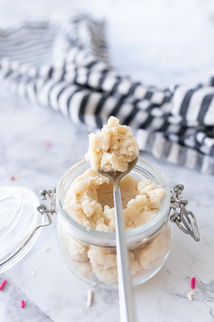 Edible cookie dough in a jar on the counter without sprinkles.