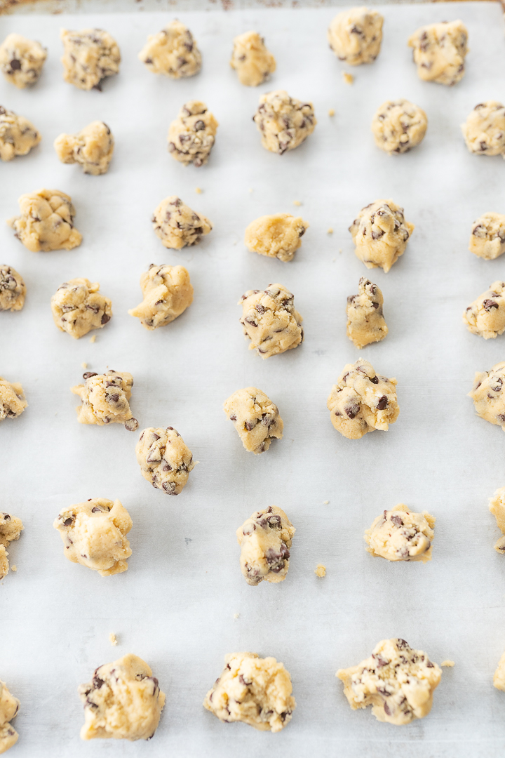 Parchment paper covered with several small balls of cookie dough.