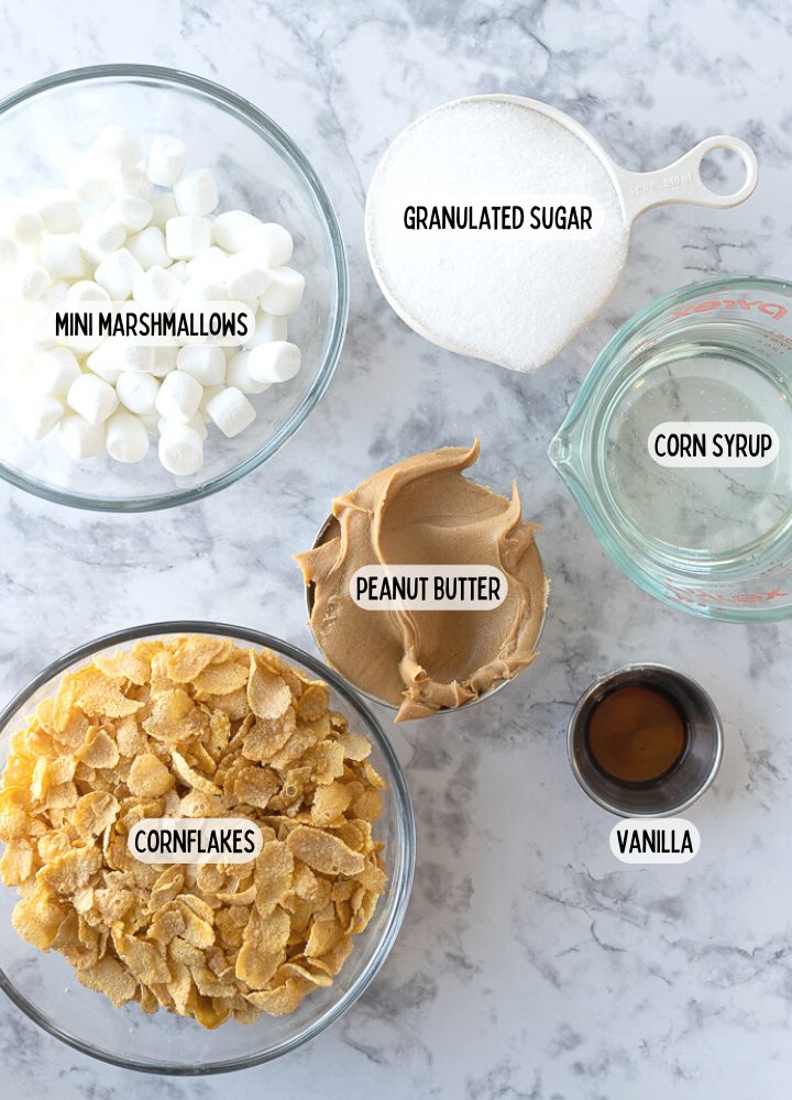 Ingredients for no bake cookies on the counter including marshmallows, sugar, karo syrup, vanilla, peanut butter, and cornflakes.