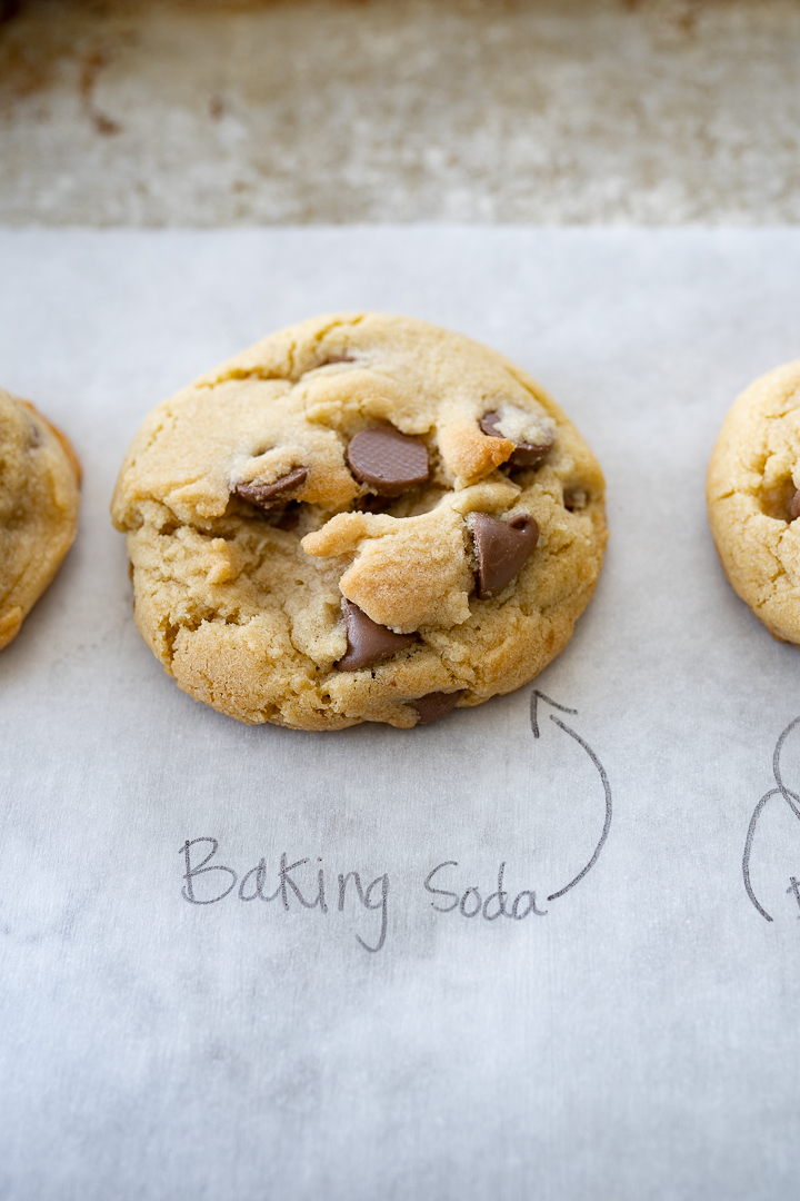 A browned cookie sits on parchment paper and is labeled baking soda. 