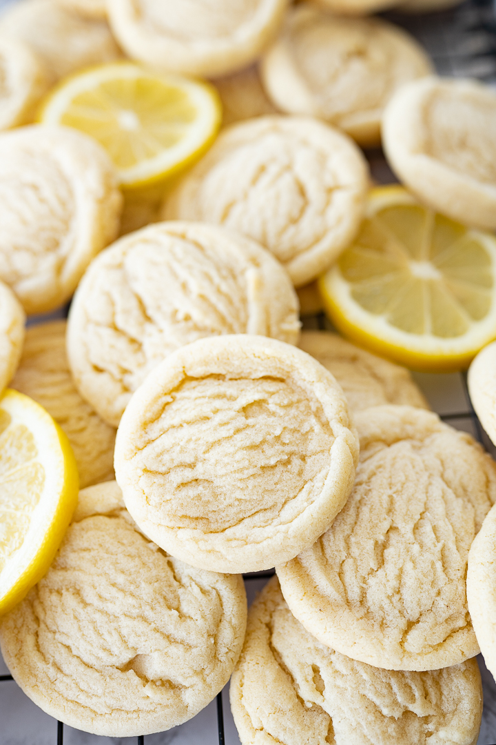 Several lemon cookies on the counter with lemon slices too.