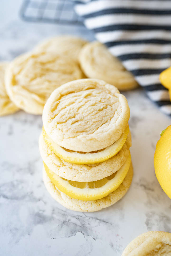 Cookies and lemon slices stacked up together on the counter.