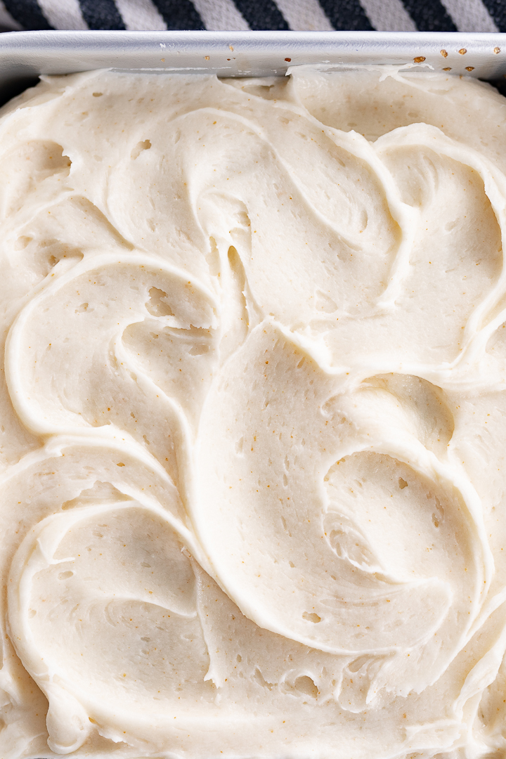 Close up of brown butter frosting filling a dish. Frosting has a swirled design.
