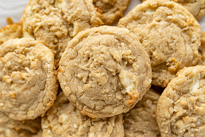 Close up of a pile of coconut white chocolate chip cookies. 