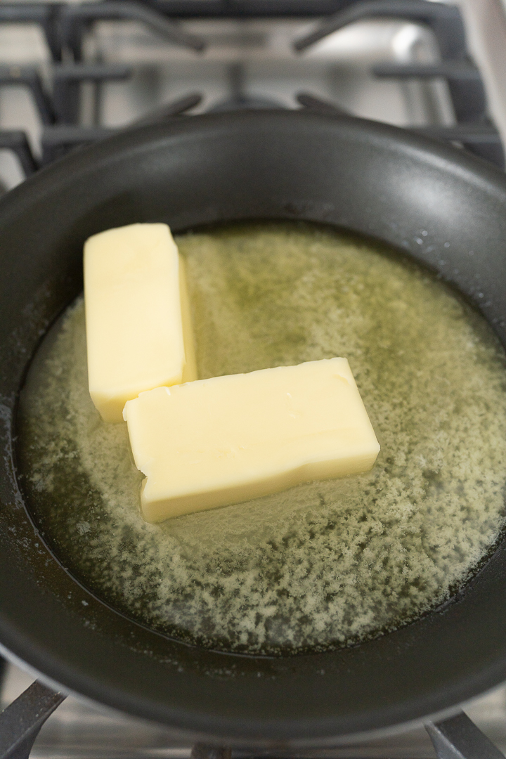 Two cubes melting in a pan on the stove. 