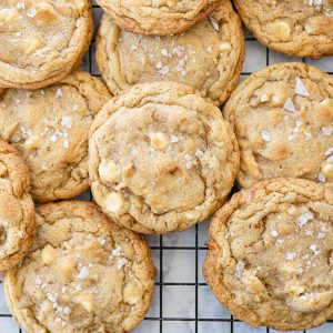 salted caramel cookies in a pile on a cookie cooling rack.