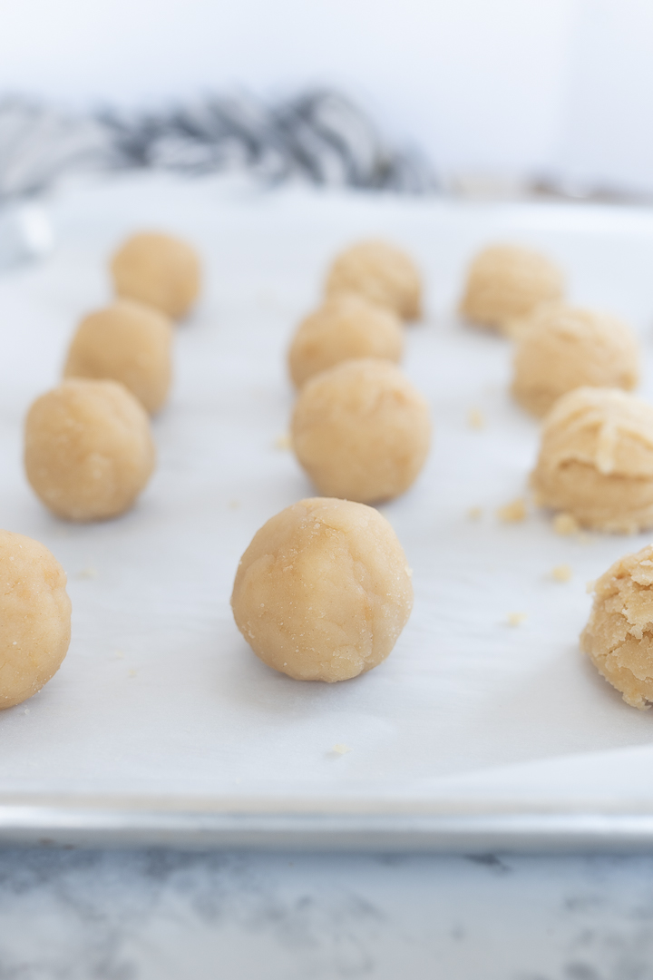 Cake balls lined on a cookie sheet prior to being dipped in chocolate.