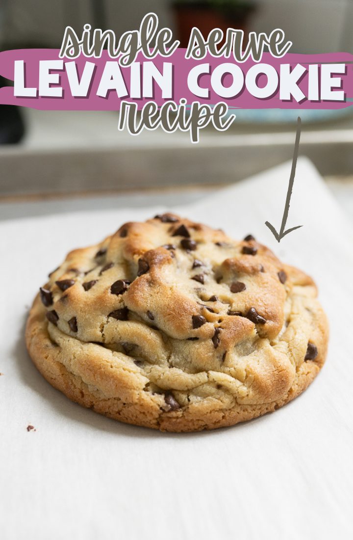 Single serve chocolate chip cookie sitting on a piece of parchment on the counter. Across the top it says "single serve levain cookie recipe"