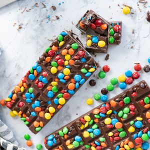 m&m chocolate candy bars on a counter with m&m's scattered around.