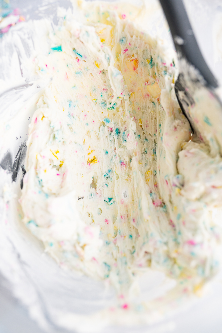 Rainbow chip frosting mixed in a mixing bowl. 