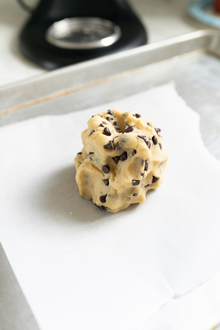 Single serve ball of cookie dough sitting on a pan ready to be baked. 