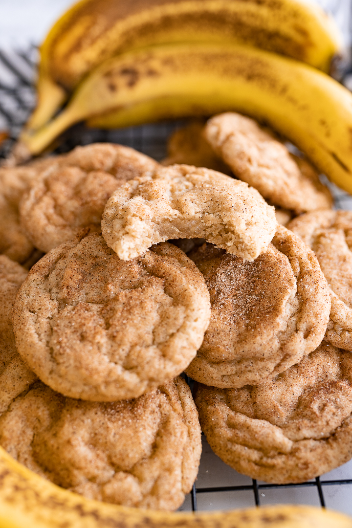 Pile of banana oatmeal cookies. One cookie has a bite out of it. 