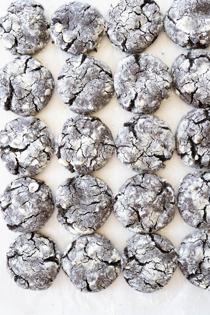 A counter lined with chocolate crinkle cookies in rows. 
