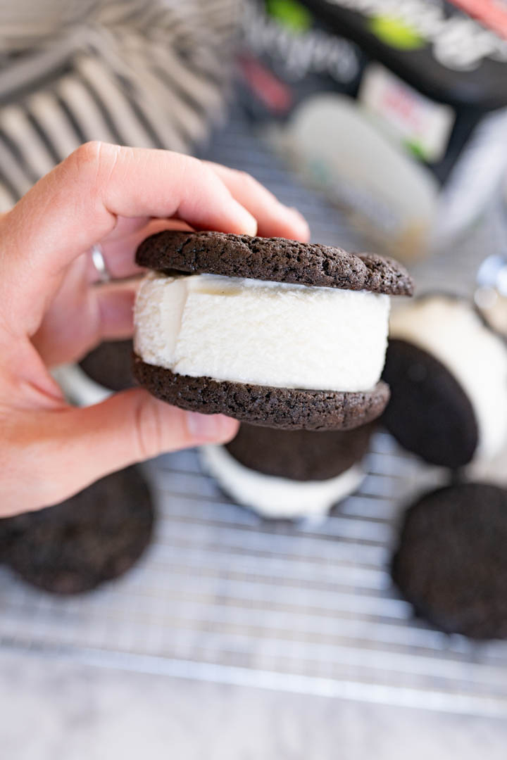 A hand holding an ice cream cookie sandwich 
