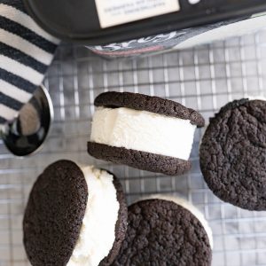 Ice cream sandwich cookies with chocolate oreo cookies and vanilla ice cream. Arranged on a wire cooling rack.