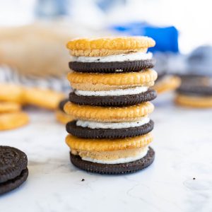 A stack of oreo cookies with ritz cracker sandwiches towering on a counter.