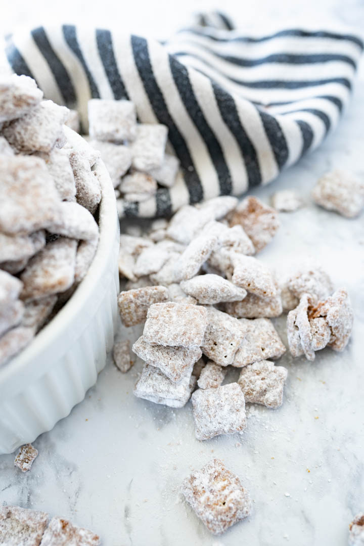 Close up of puppy chow that has fallen out of a bowl on to the counter. 