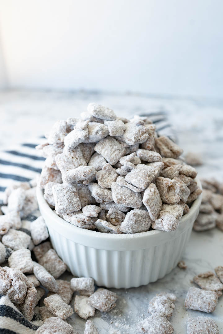 Overflowing bowl of puppy chow, spilling out onto the counter. 