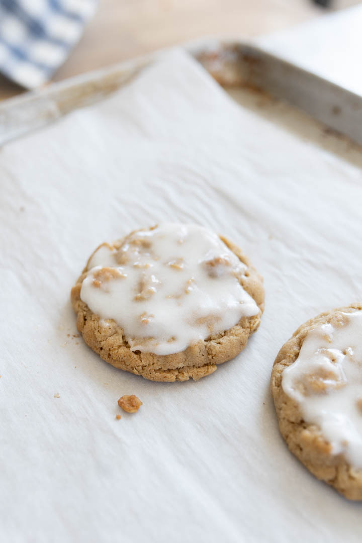 Two cookies topped with powdered sugar icing.