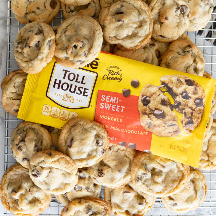 A bunch of nestle toll house cookies stacked on a chocolate chip package.