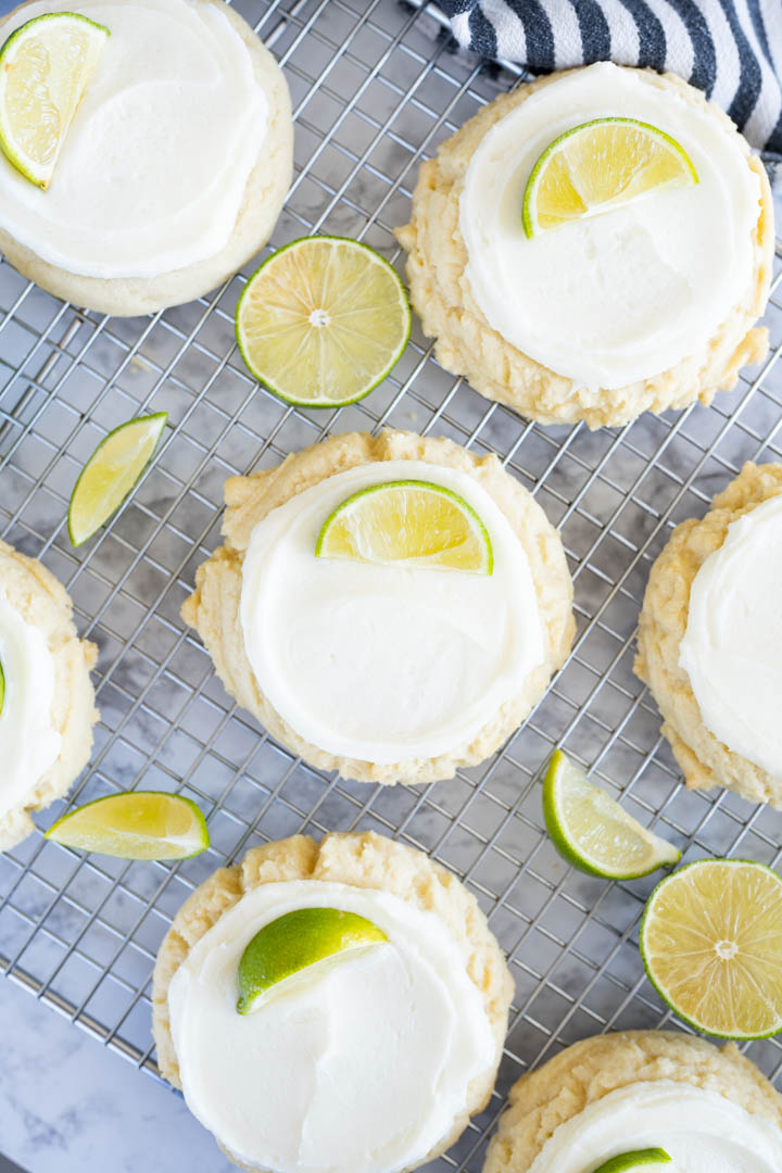 Aerial view of multiple twisted sugar coconut lime cookies topped with lime slices.