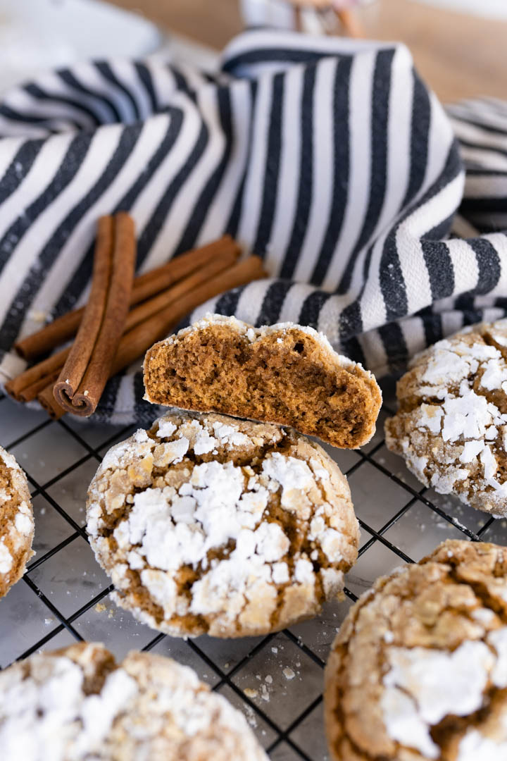 Pumpkin crinkle cookies on a wire cooling rack. One half of a cookie on top of a whole cookie. 