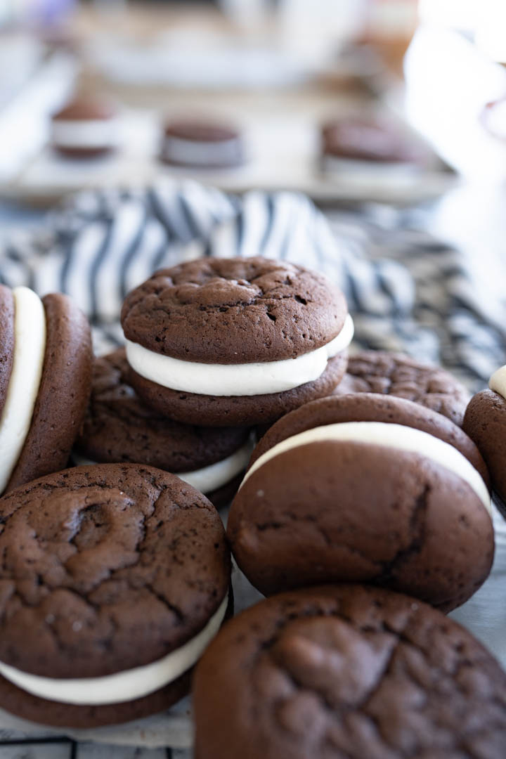 Close up of a chocolate whoopie pie cookie on top of a pile of cookies. 