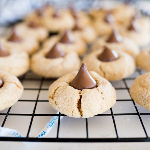 Side view of peanut butter blossom cookies on a wire cooling rack.