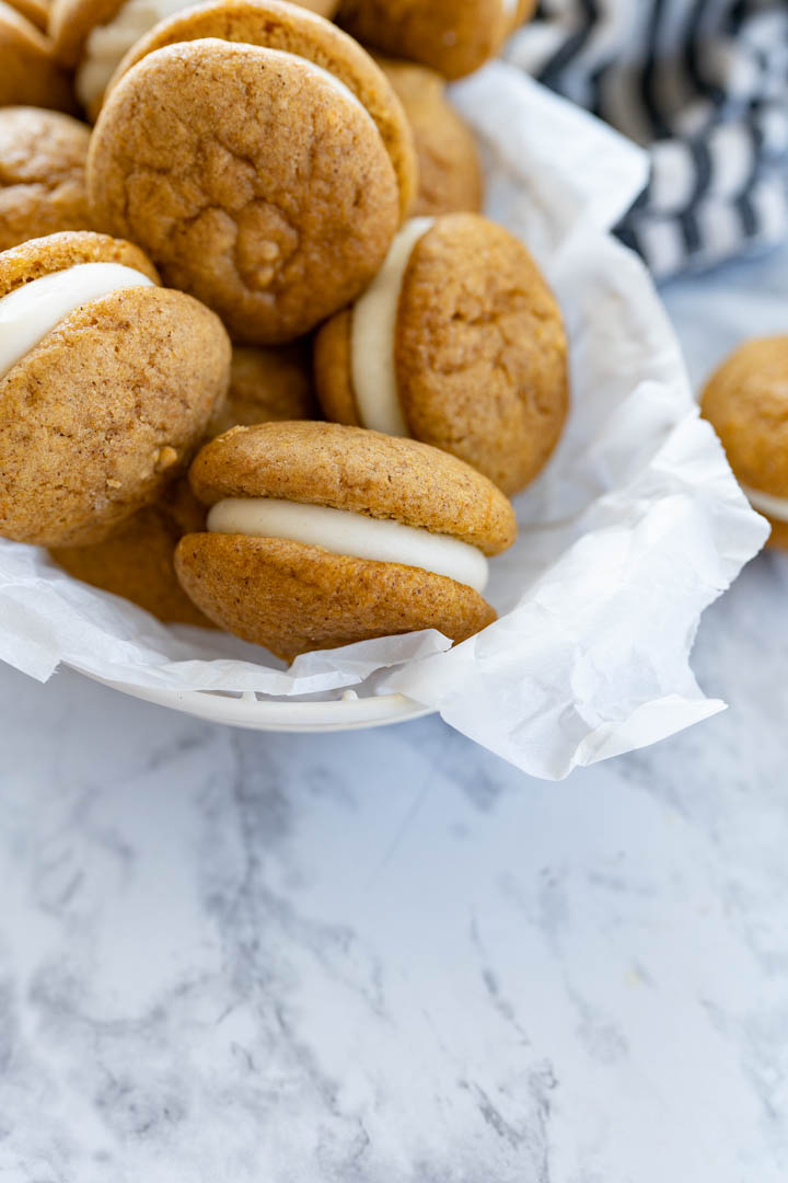 A bowl of pumpkin whoopie pies just out of the frame. 
