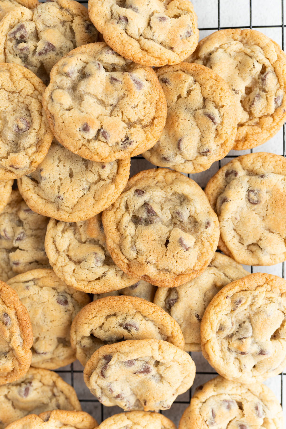 A close up of a giant pile of ghirardelli chocolate chip cookies.