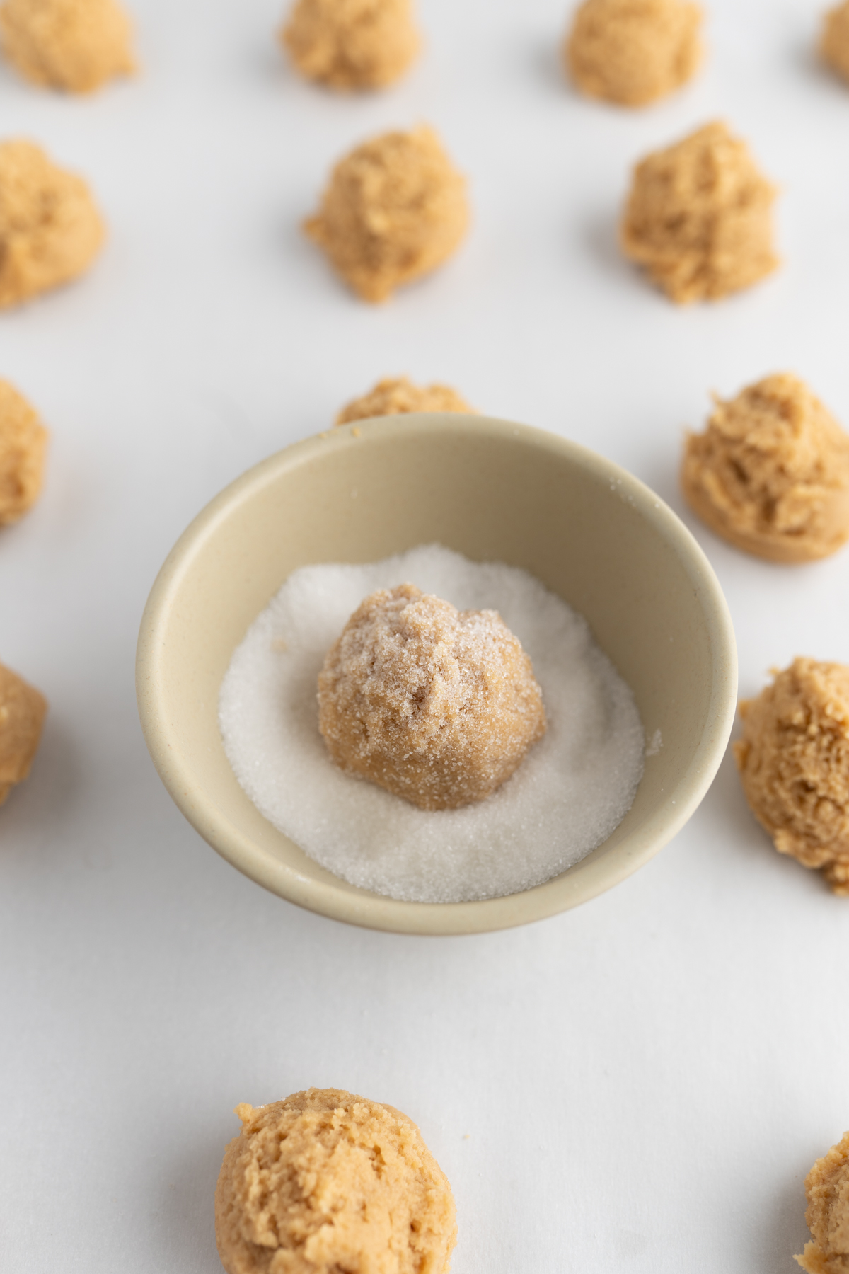 Recipe for peanut butter cookies - one dough ball in a bowl of sugar to roll and coat. 