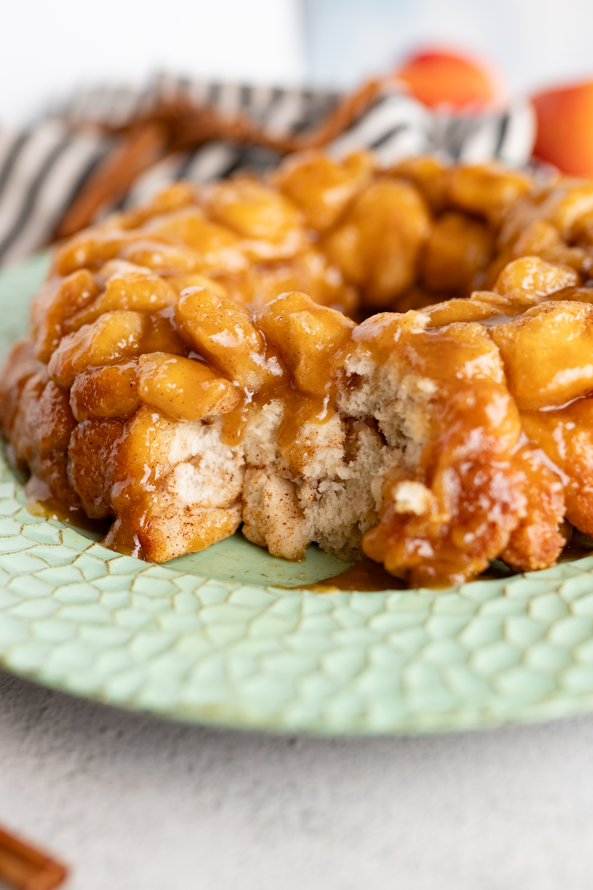 monkey bread with a portion of the bread removed, showing the buttery and cinnamony inside of the bread. 