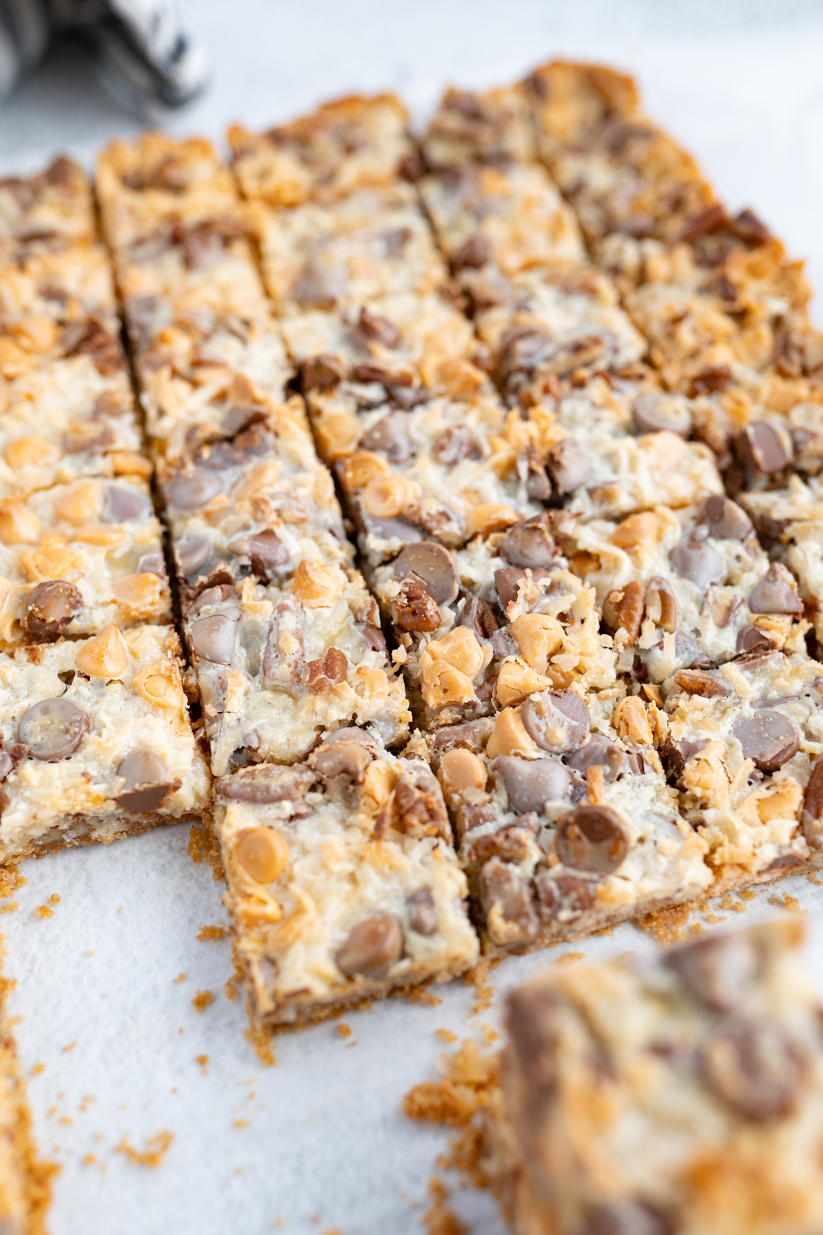A pan of 7 layer bars cut into squares with one square missing. 