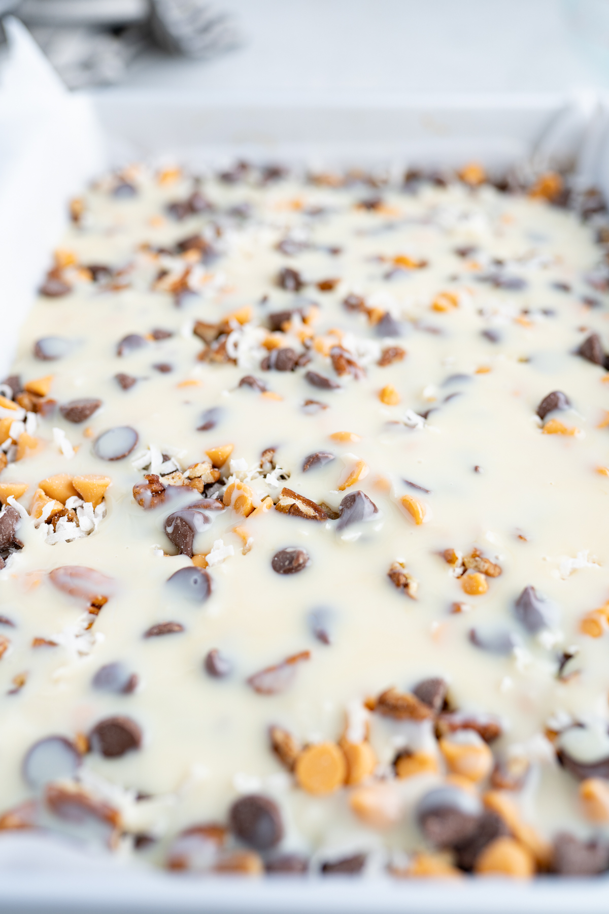Sweetened condensed milk poured over toppings to make 7 layer bars. 