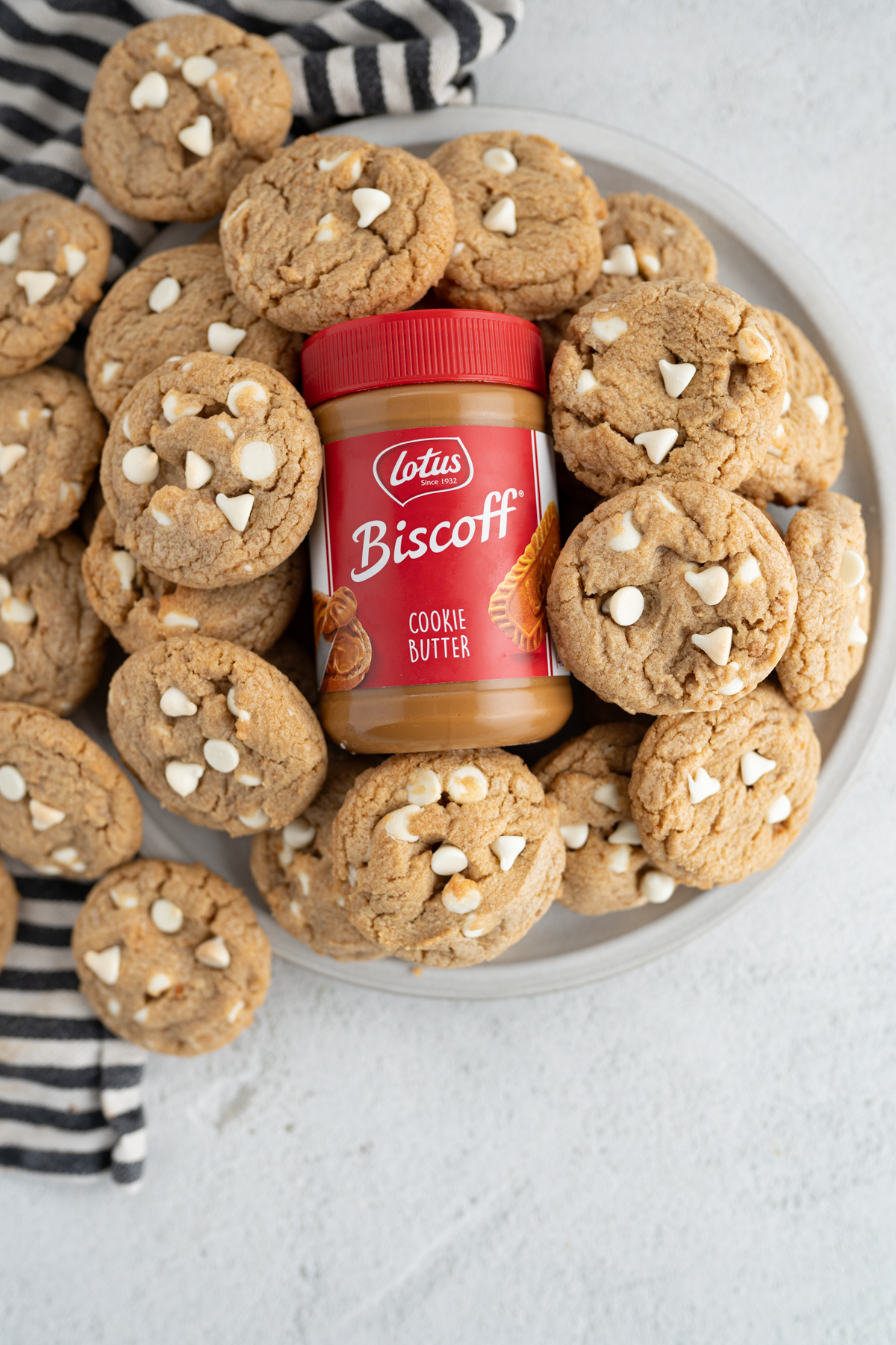 A bowl of biscoff cookies surrounding a jar of biscoff butters. 
