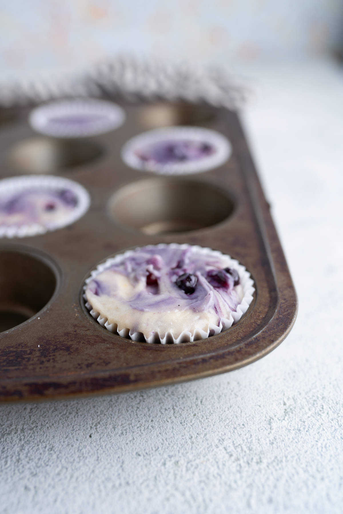 Blueberry muffin batter in a cupcake pan. 