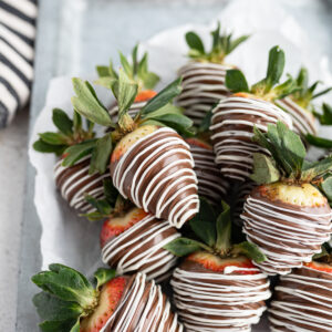 Image of chocolate covered strawberries drizzled with white chocolate.