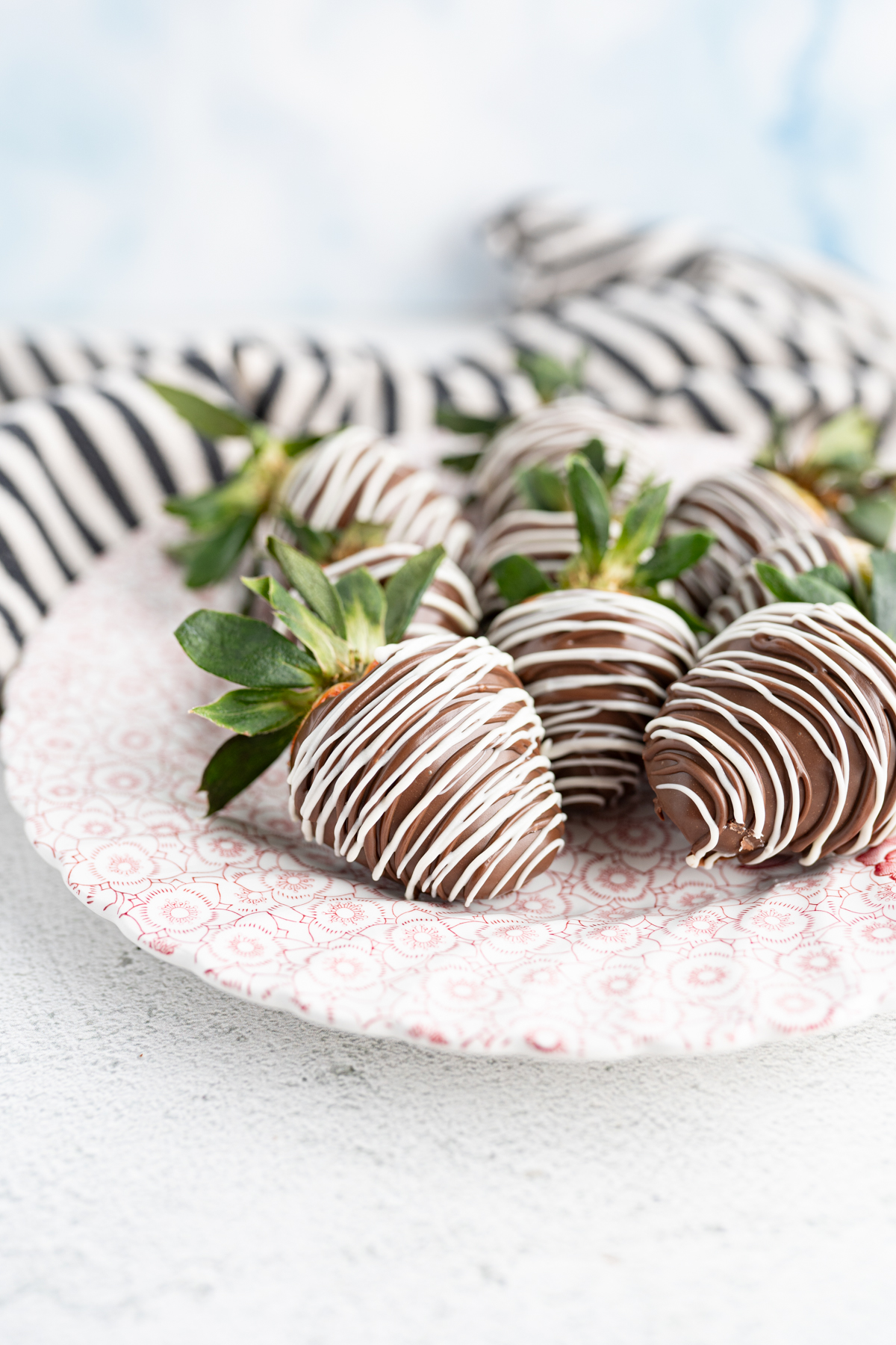 A plate of chocolate covered strawberries. 