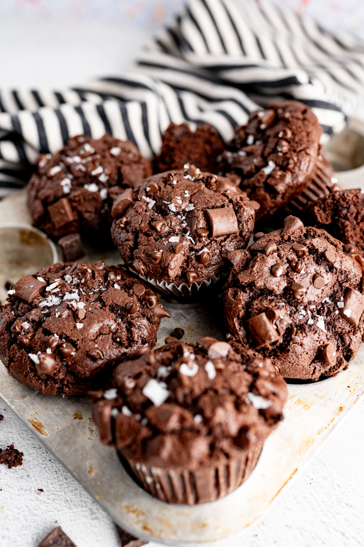 A pile of bakery-style double chocolate muffins. Perfectly moist with an impressive bakery-domed top and THREE types of chocolate chips, these chocolate chocolate chip muffins.