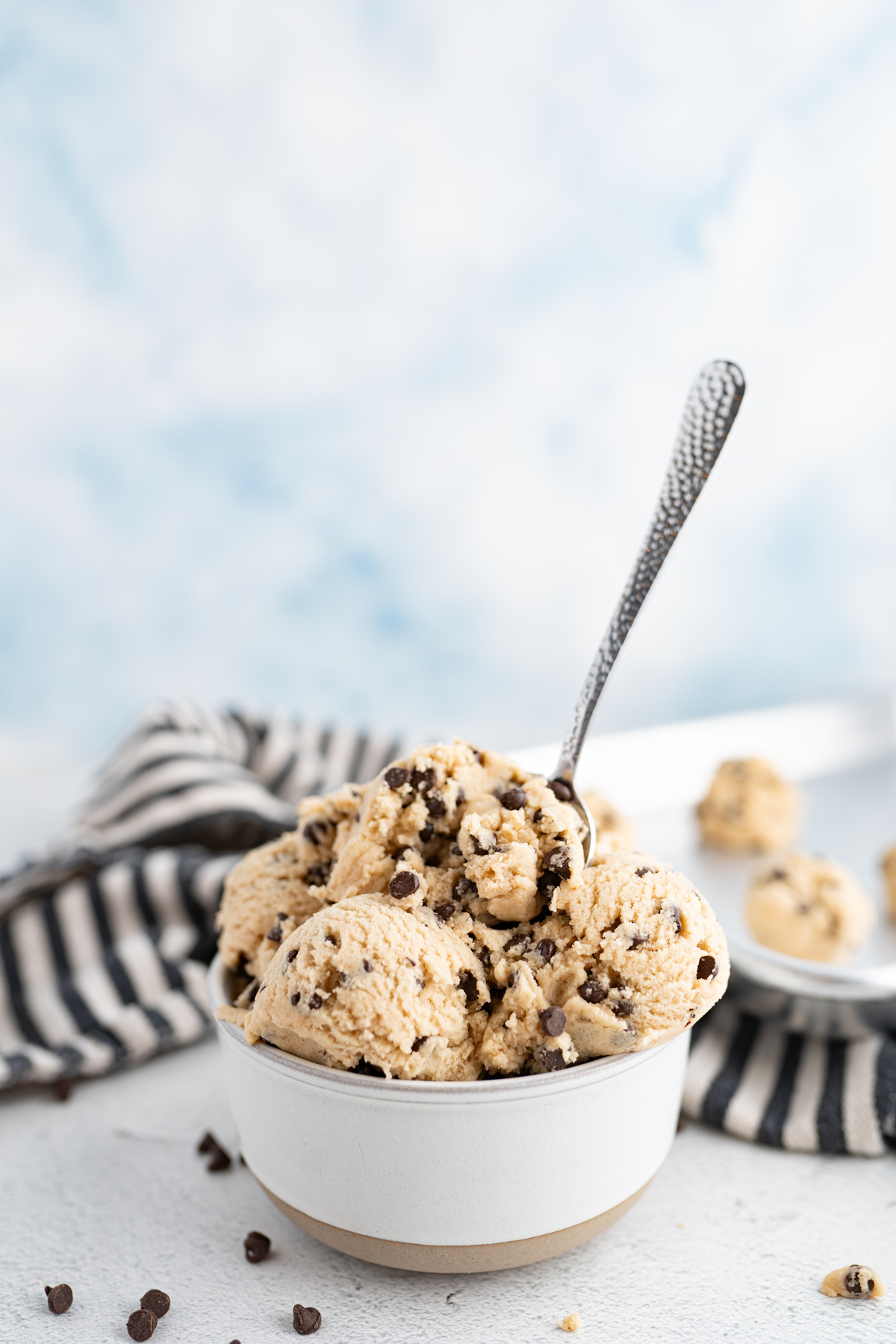 A bowl of edible cookie dough with a spoon sticking out of it. 
