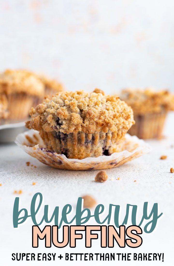 Close up of a single blueberry muffin on it's wrapper sitting on the counter. Across the bottom it says "blueberry muffins, super easy, better than the bakery" in text.