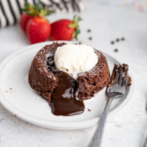 A plate of chocolate lava cake with chocolate oozing out.