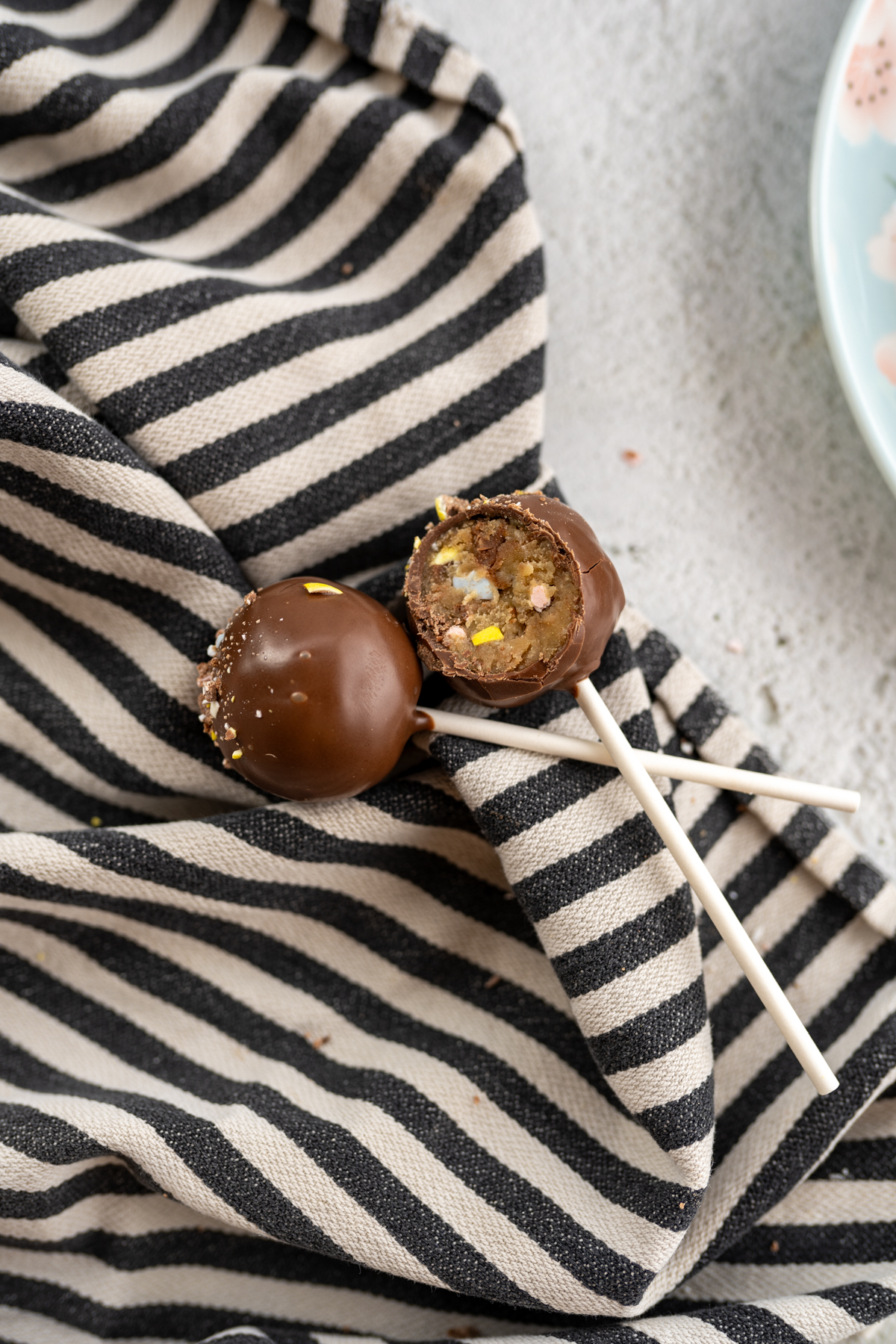 Two cadbury egg cake pops on the counter. 