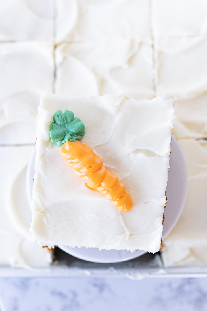 Aerial view of carrot cake with a frosting carrot on top. 