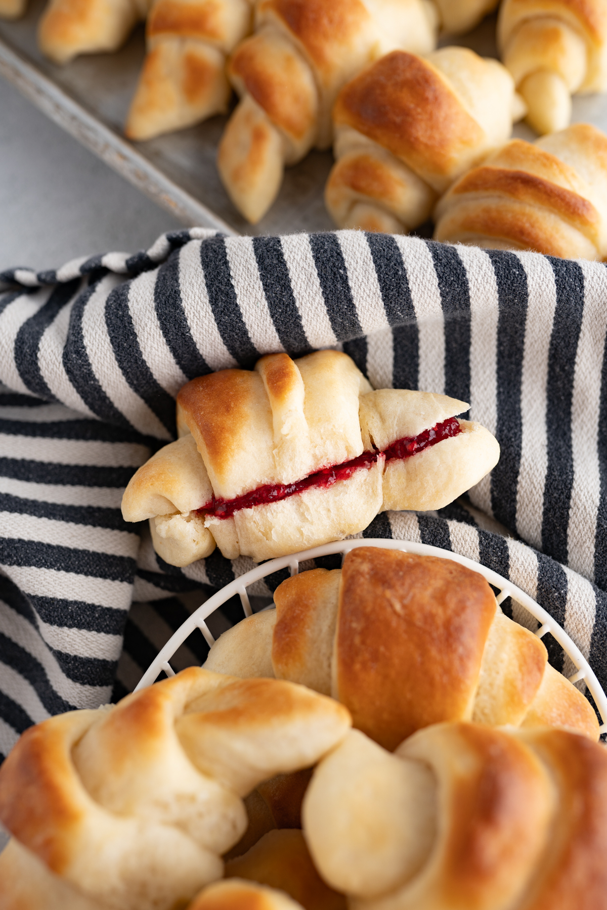 A crescent roll cut in half and filled with jam.