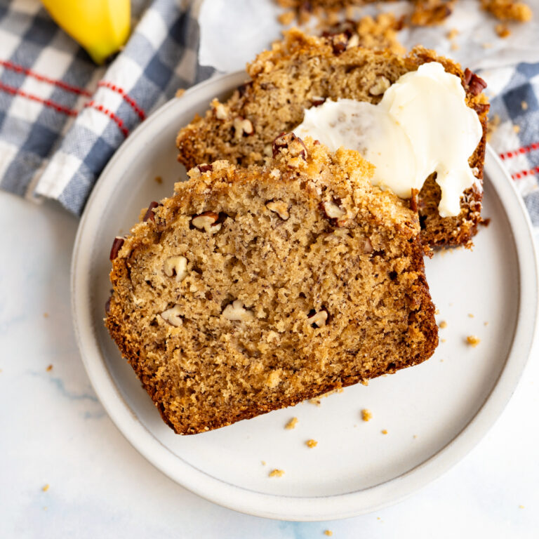 Two slices of homemade banana bread on a plate.